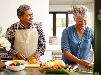 An older couple preparing healthy foods to eat