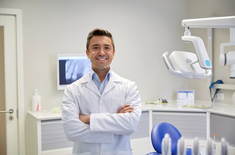 A smiling male cosmetic dentist in a dental office